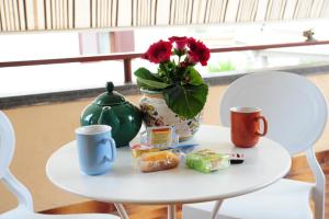 un tavolo con vaso di fiori e tazze di caffè di Civico 34 a Caserta