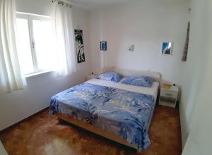 1 dormitorio con cama con sábanas azules y ventana en Apartment Merara, en Sevid