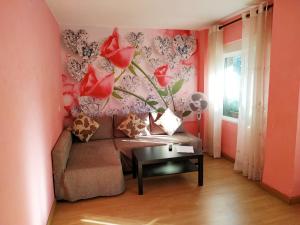 uma sala de estar com um sofá e flores na parede em Apartamento Turistico en Valencia em Valência