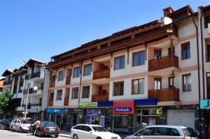 a large building with cars parked in front of it at Family Hotel Nadine in Bansko