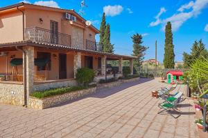 a house with a patio and a playground at Villa Sansone in Altavilla Milicia