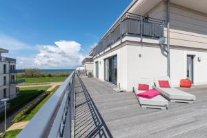 a balcony of a building with two chairs on it at Villa Bernstein in Börgerende-Rethwisch