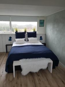 a bedroom with a large bed and a large window at B&B Duinroos De Koog - Texel in De Koog
