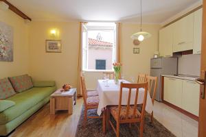 eine Küche und ein Wohnzimmer mit einem Tisch und einem Sofa in der Unterkunft Apartments Kovac Old Town in Dubrovnik