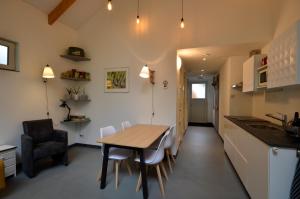 DINOS Bed&Breakfast - Private Guesthouse في Eelderwolde: مطبخ وغرفة طعام مع طاولة وكراسي