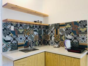 cocina con fregadero y pared de azulejos en The Stay Apartment Pleiku en Pleiku