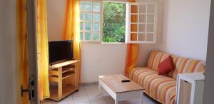 Una sala de estar con un sofá y una ventana. en TI-COLO, en Sainte-Anne
