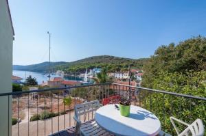 a balcony with a table and chairs and a view of the water at Apartment Meri - sea view & serenity in Božava