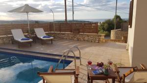 una piscina con mesa y sillas y una piscina en Sharon's Stone Villa, en Rethymno