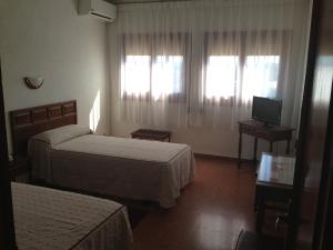 um quarto de hotel com duas camas e uma televisão em Hotel-Motel Sol II em Requena