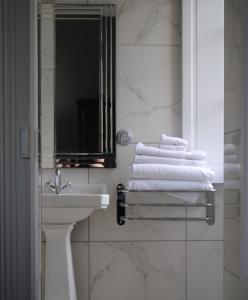 bagno con lavandino, specchio e asciugamani di Chateau Mezger ad Albefeuille-Lagarde