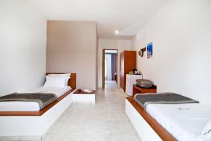 two beds in a room with white walls at Acrotel Elea Beach in Elia