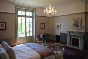 una camera con letto, camino e lampadario a braccio di Chateau Mezger ad Albefeuille-Lagarde Altre 37 foto