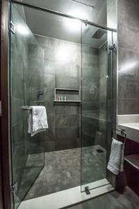 a shower with a glass door in a bathroom at Glam Hotel Nairobi - Near Westgate Mall, Westlands in Nairobi