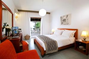 a bedroom with a bed and a desk and a chair at Acrotel Elea Beach in Elia