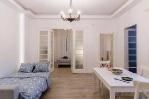 ein weißes Wohnzimmer mit einem Bett und einem Tisch in der Unterkunft White Nights of Old Town Bucharest in Bukarest
