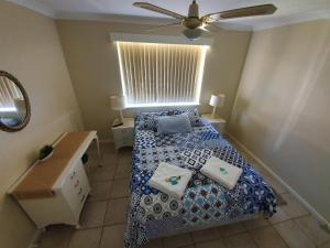 a bedroom with a bed with pillows on it at Ocean Beach Chalet 15 in Jurien Bay