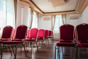 a row of red chairs sitting in a room at Hotel Onix in Cluj-Napoca