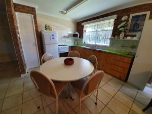 a kitchen with a table and chairs and a refrigerator at Ocean Beach Chalet 15 in Jurien Bay