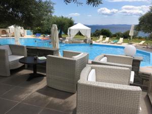 a group of chairs and a pool with a table at Acrotel Elea Beach in Elia