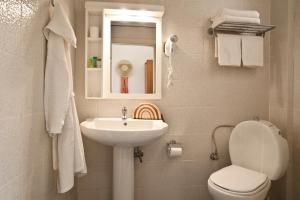 a bathroom with a sink and a toilet and a mirror at Acrotel Elea Beach in Elia