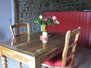 une table en bois avec deux chaises et un vase avec des fleurs dans l'établissement Domaine des Gardette, à Vaux-en-Beaujolais
