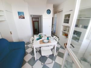 a small room with a table and a blue couch at Casa con terrazza vista 180° sulla costa orientale in Santa Cesarea Terme