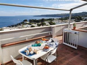 un balcone con tavolo e cibo sopra di Casa con terrazza vista 180° sulla costa orientale a Santa Cesarea Terme