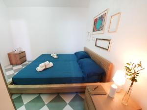 una camera da letto con un letto blu con due asciugamani di Casa con terrazza vista 180° sulla costa orientale a Santa Cesarea Terme