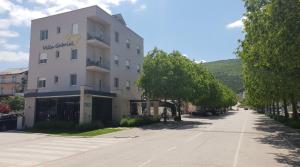 un bâtiment blanc avec un panneau dans une rue dans l'établissement Villa Gabriel, à Međugorje