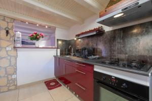 a kitchen with red cabinets and a stove at ANNECY Sainte Claire vieille ville 38m2 Terrasse proche gare et lac 4 pers 3 étoiles in Annecy +18 photos