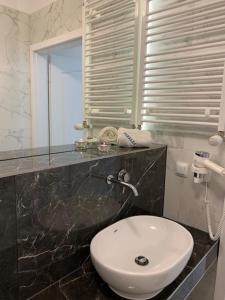 a bathroom with a white toilet and a sink at Apartament Bursztynowy in Kołobrzeg