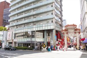神戶的住宿－神戸元町東急REI飯店，一辆汽车在繁忙的城市街道上的建筑