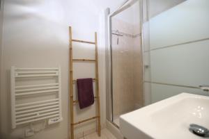 y baño con ducha, lavabo y espejo. en Appart Le Concorde en Saint-Gilles-Croix-de-Vie
