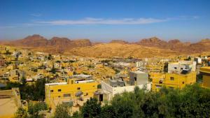 una vista di una città con le montagne sullo sfondo di Valentine Inn a Wadi Musa