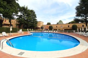 una grande piscina con sedie e ombrelloni di Appartamenti La Madonnina a Peschiera del Garda