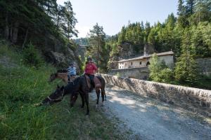 twee mensen die paardrijden op een onverharde weg bij Byne - Residence Le Cheval Blanc Valfréjus in Valfréjus