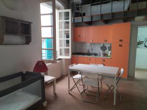 a kitchen with orange cabinets and a white table and chairs at Al Chiostro Guesthouse in Genoa