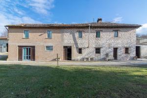 un gran edificio de ladrillo con un campo de hierba delante de él en Casa Sponge B&B, en Pergola