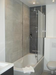 a bathroom with a bath tub and a toilet at Les Embruns in Trouville-sur-Mer