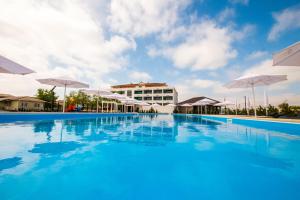 a large swimming pool with umbrellas in front of a building at WELCOME summer in Zatoka
