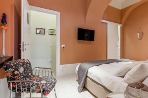 um quarto com uma cama e uma cadeira em TreSette Toledo em Nápoles