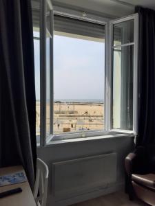 a window in a room with a view of a beach at Les Embruns in Trouville-sur-Mer