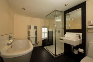 a bathroom with a sink, toilet and bathtub at Sun Inn in Kirkby Lonsdale