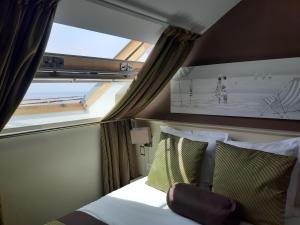 a bedroom with a bed and a window with a picture of a beach at Les Embruns in Trouville-sur-Mer