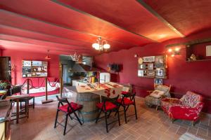 sala de estar con paredes rojas, mesa y sillas en Casa Sponge B&B en Pergola