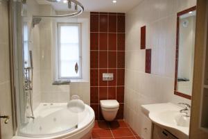 a bathroom with a tub and a toilet and a sink at Gîtes les bains in Riquewihr +35 photos