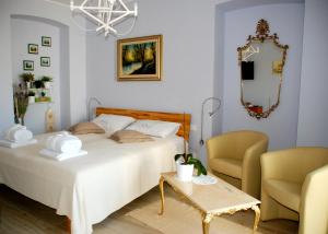 a bedroom with a bed and a chair and a mirror at Sotto il Faro B&B - Trieste in Trieste