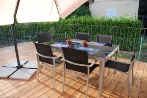 einen Tisch und Stühle auf einer Terrasse mit einem Sonnenschirm in der Unterkunft Sotto il Faro B&B - Trieste in Triest
