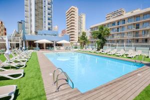 a large swimming pool with lounge chairs and buildings at Benidorm Centre - Adults Only in Benidorm